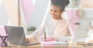 woman taking notes in front of laptop